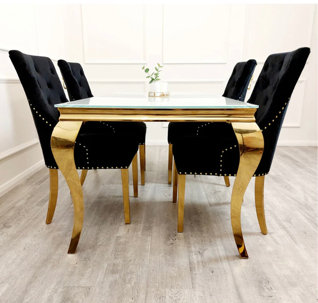 Louis gold white glass dining table with black Bentley chairs